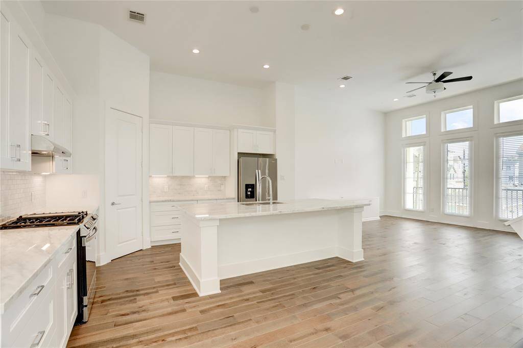 A view from the dining area. Quality stainless steel appliances, a walk-in pantry, ample counter space, and a huge kitchen island all make hosting guests a breeze.