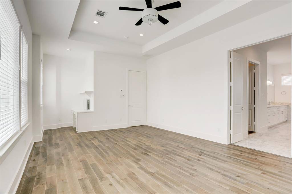 Another angle of this fantastic primary bedroom. One unique feature of this room is the vanity area at the far end of the room. Thanks to the perfect lighting, this area is ideal for doing hair and makeup, but it can also be used as a desk.