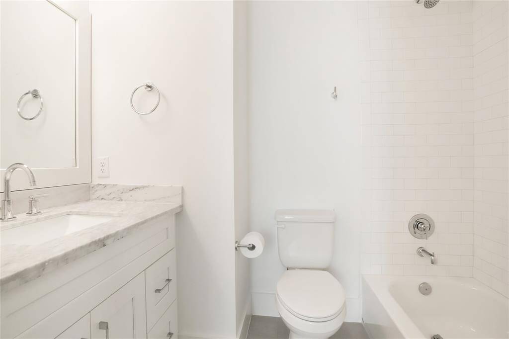 The ensuite bath for the upstairs secondary bedroom, with plenty of counter space and a tub/shower combo.