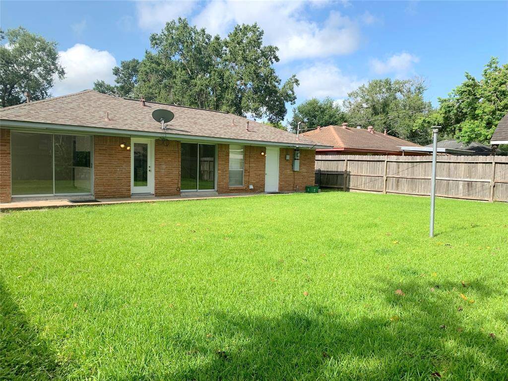 Rear view of house with large back yard. Notice all the big windows and security lights! Upgraded electric box!
