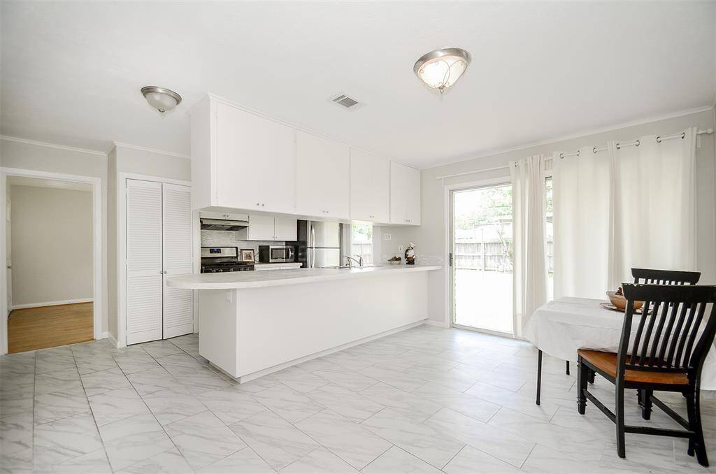 Tile floors in kitchen and dining room. Notice upper cabinets can be opened from the dining room side too.
