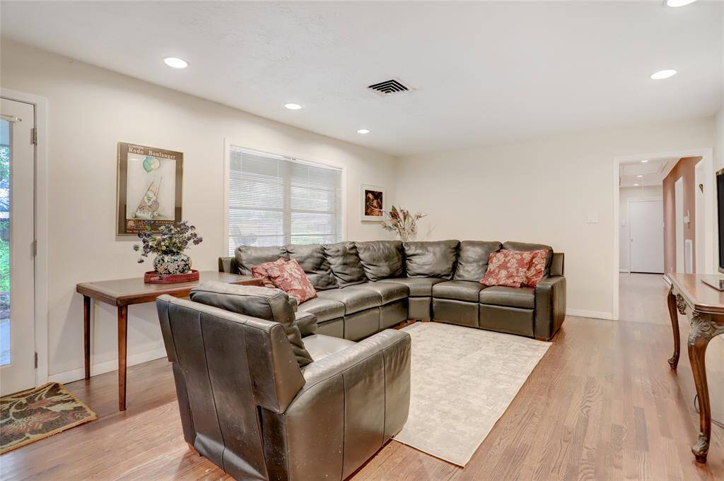 The family room with hardwood floors and recessed cans with a view of the backyard.