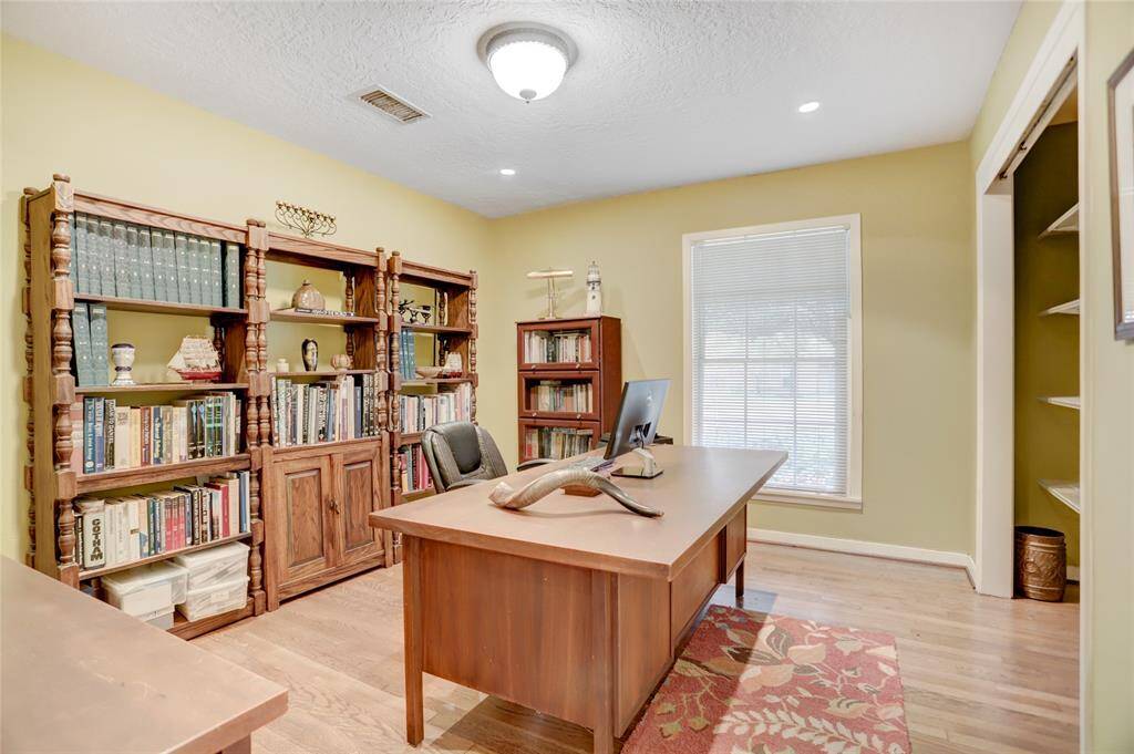 Middle bedroom being used as a study with recessed cans and shelving in the closet.