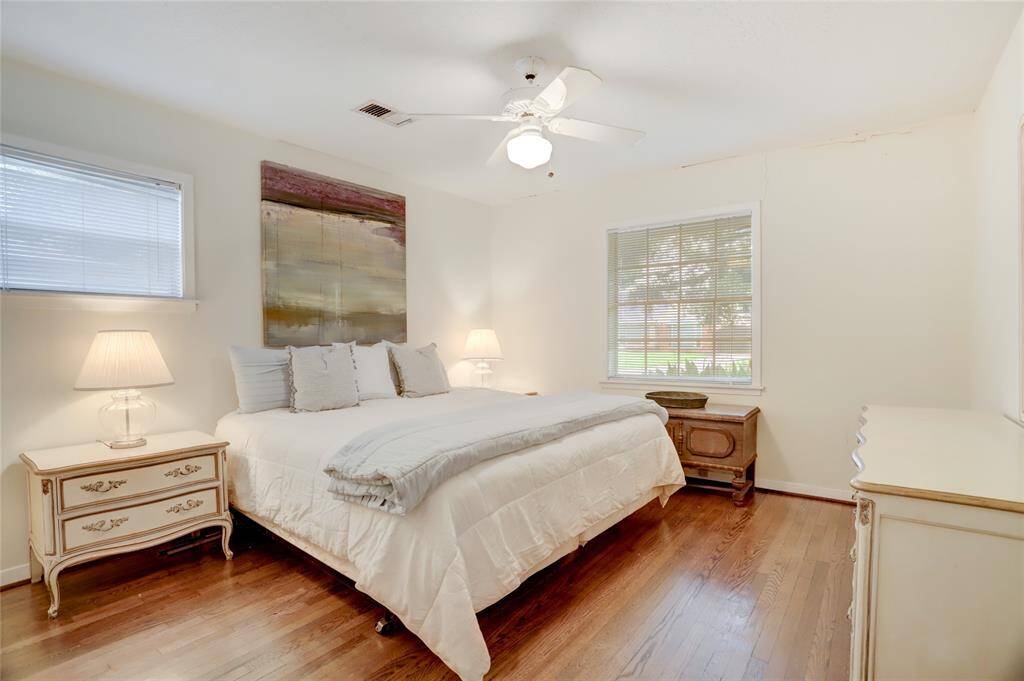 Front corner bedroom with two windows, nice sized walk-in closet, and hardwood floors.