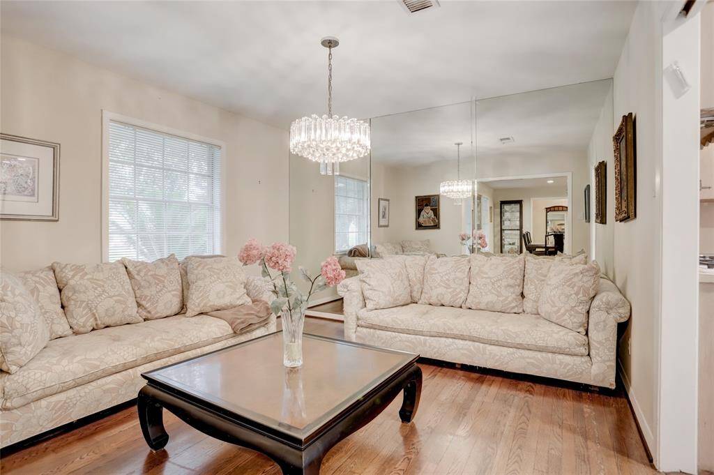 The original dining room with chandelier and mirrored wall being used as a sitting area