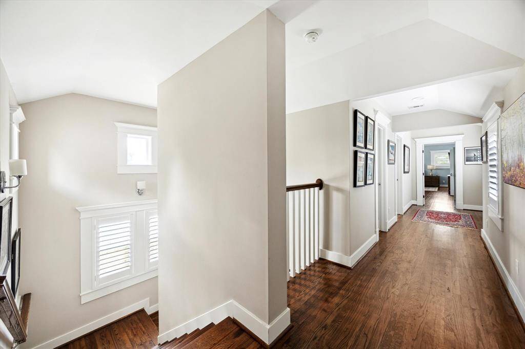 Bringing warmth and flow to the upper level, this stairway opens to a wide gallery hall lined with hardwood floors, natural light, and classic trim details. The layout offers easy access to upstairs bedrooms and creates the perfect backdrop for showcasing art or family photos.