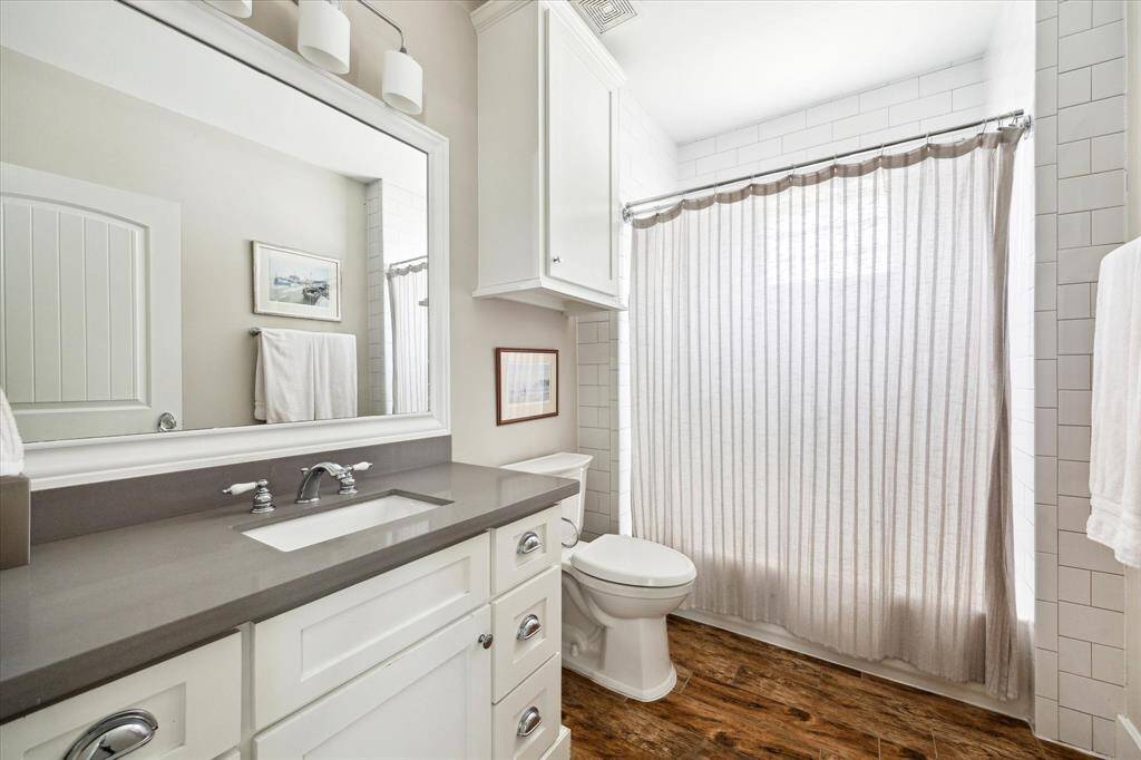 Well-appointed and conveniently located on the ground floor, this secondary bathroom features a sleek quartz countertop, classic cabinetry, and a tub-shower combo with subway tile surround. Ample storage and polished finishes make it both functional and stylish for guests or daily use.