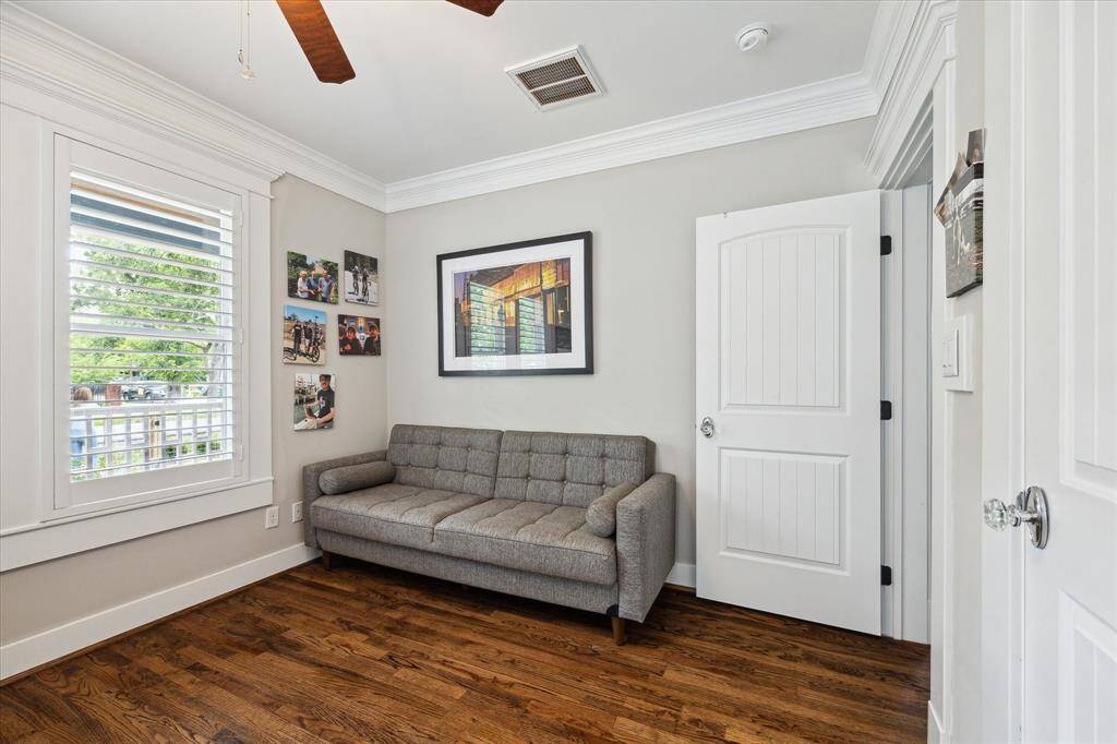 Filled with natural light and front-facing views, this ground-floor secondary bedroom is currently used as a home office. Plantation shutters, hardwood floors, and detailed crown molding add charm and versatility, making it equally suited for use as a guest room, nursery, or study.