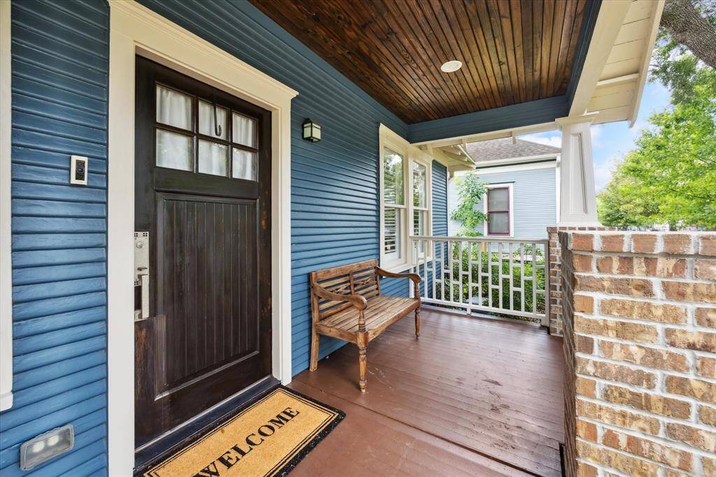 Welcoming and full of charm, the front porch features a rich wood-paneled ceiling, brick accents, and classic railing details. This inviting space sets the tone for the home, offering a quiet spot to enjoy the neighborhood and shaded comfort beneath mature trees.
