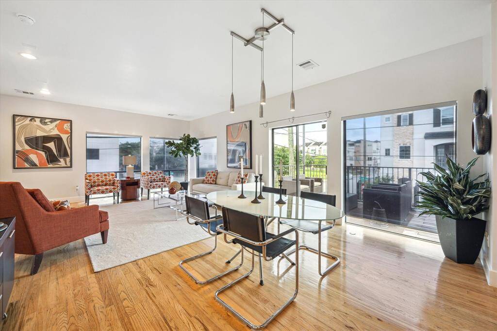 Bright second-floor living and dining area featuring elegant hardwood floors and abundant natural light.