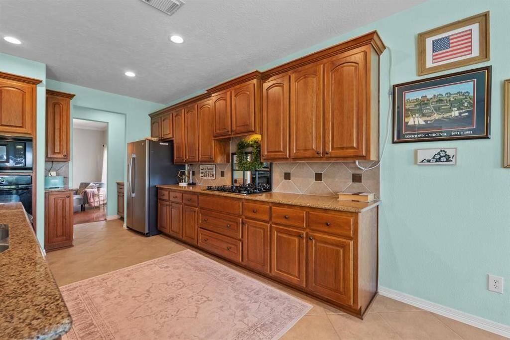 Granite countertops with tile backsplash with granite inserts, makes the kitchen a great space for preparing your meals or gathering with your family