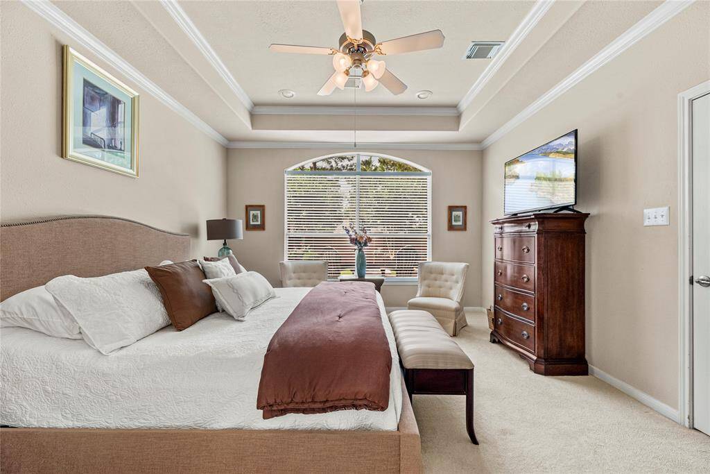 The spacious primary suite features tray ceilings and elegant crown molding, creating a sophisticated space.