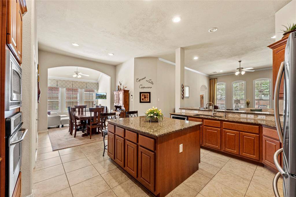 The sprawling island with breakfast bar seating serves as a versatile centerpiece, providing additional workspace, storage, and seating for casual dining.