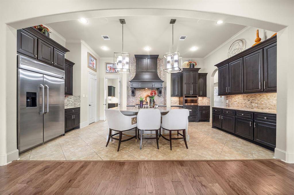 Custom Monogram Refrigerator and High End Monogram Range with Beautiful Rustic Backsplash, with convenient pot filler!
