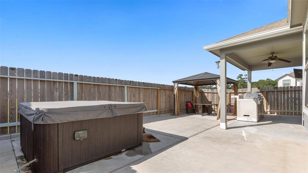 Back covered patio with fan, stainless steel BBQ Grill and mini fridge (Jacuzzi & TV also included in sale)