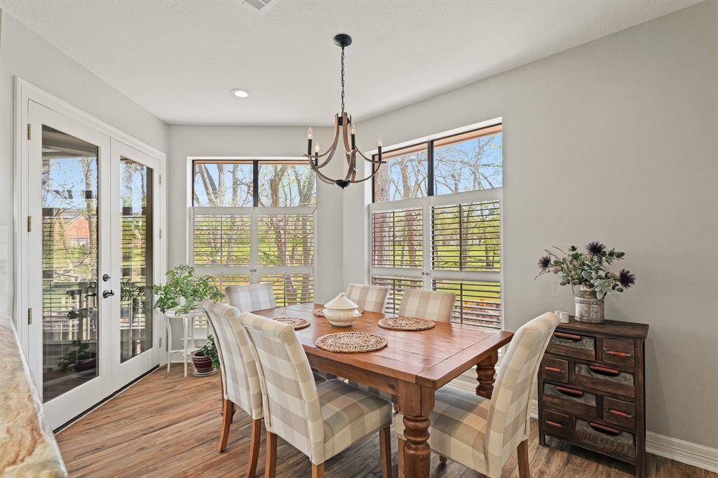 The Breakfast Room is bathed in natural light thanks to the large windows adorned with plantation shutters. Glass-plated French doors lead to the screened-in Porch beyond.