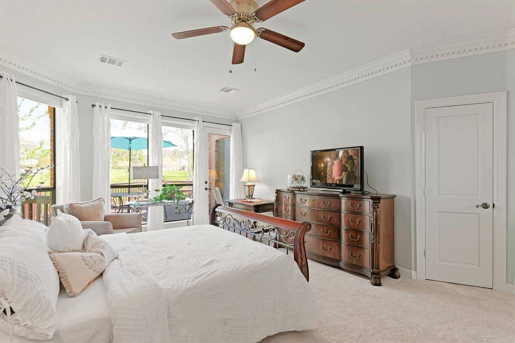 The trio of floor-to-ceiling windows ushers in warmth and sunlight. A glass-plated door provides direct access to the back Deck and serene Backyard beyond. The closed door to the right provides access to a walk-in closet.