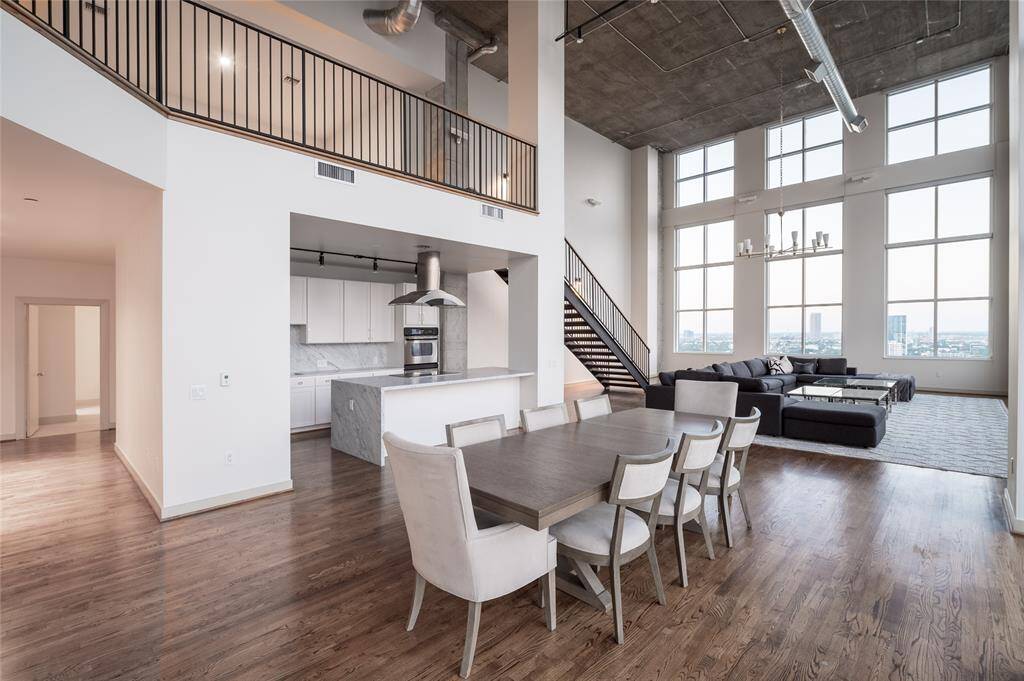 This stunning two-story residence combines raw architectural elements with refined modern finishes, featuring soaring ceilings, exposed steel and brick, and dramatic floor-to-ceiling windows that frame panoramic views of the city skyline.