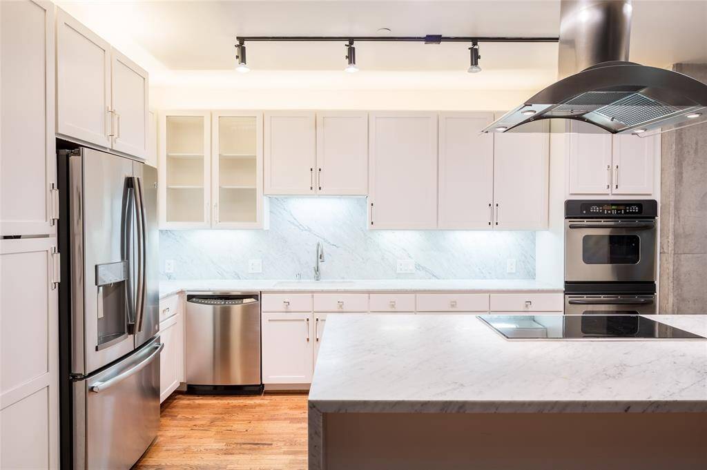 The newly renovated kitchen sports new cabinets, countertops, backsplash, cooktop, and vent hood, in addition to the stainless steel appliance package.