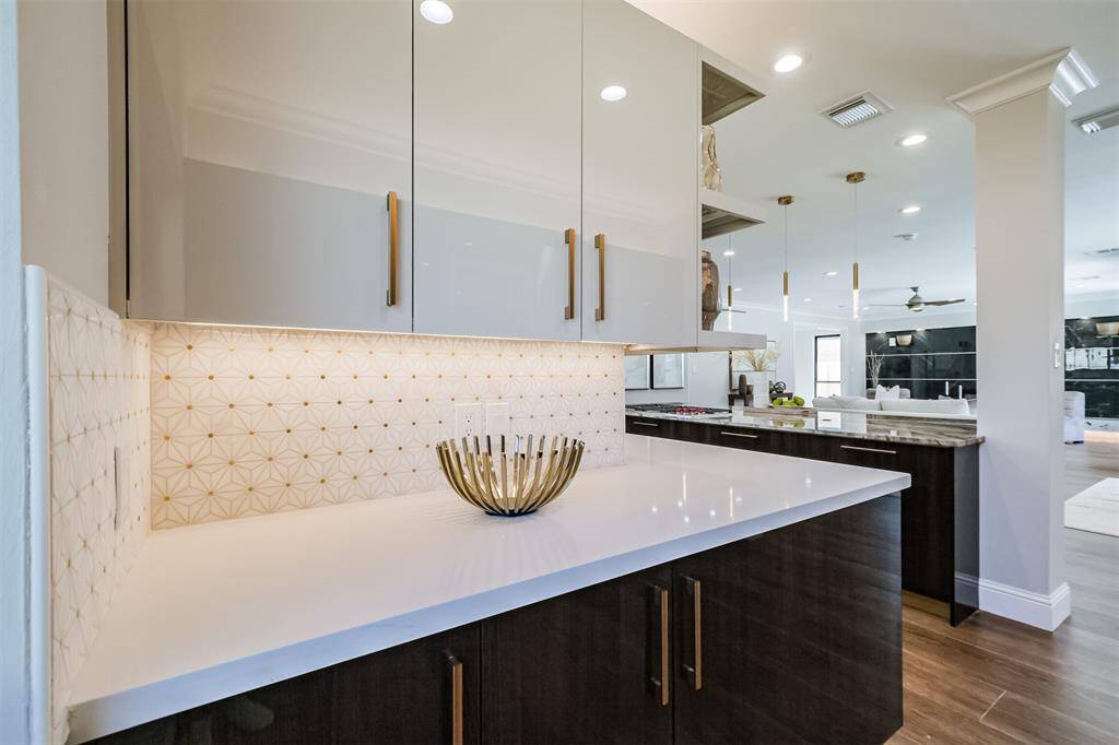 Wrap around cabinets with open shelving and miles of Quartz counters make great use of this breakfast niche.