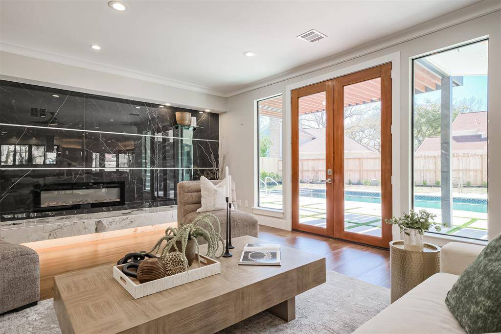 Oversized Pella double pane windows and modern wood and glass panel French door provide a serene view to your back yard and pool and provides an abundance of natural light in the space. (previously staged)