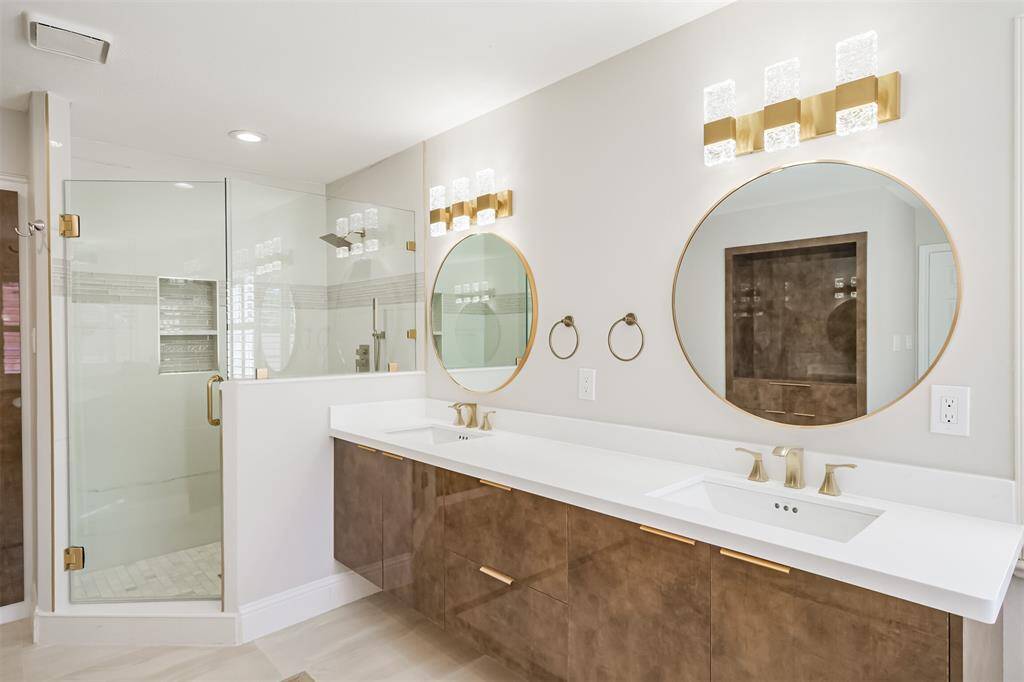 This modern and expansive primary bathroom is a testament to contemporary luxury. The tastefully remodeled space showcases sleek Alvic floating cabinetry, exuding elegance and providing an airy, spacious feel. Immaculate quartz countertops complement the minimalist aesthetic, offering durability and style, while the frameless glass shower adds a touch of sophistication with its clean lines and refined appearance.
