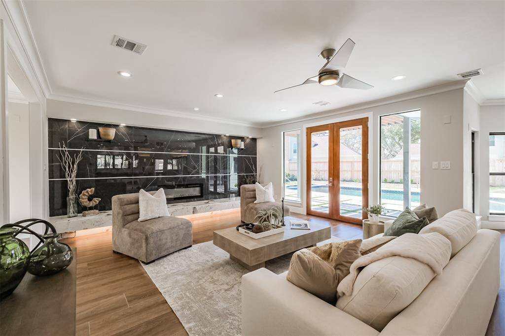 This residence boasts an unmatched open-concept modern design, creating a bright and inviting atmosphere with a seamless transition to outdoor living. The statement living room wall features two toned porcelain tile surrounding the electric fireplace with a floating mantle and undermounted LED light bar to ensure the perfect ambiance. (previously staged)