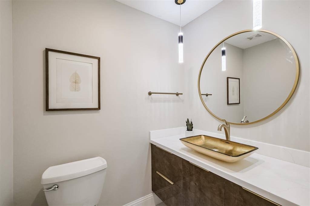 The powder bath is equally beautiful and functional with its Kraus glass vessel sink, Grohe faucet, quartz counters and floating Alvic cabinetry.