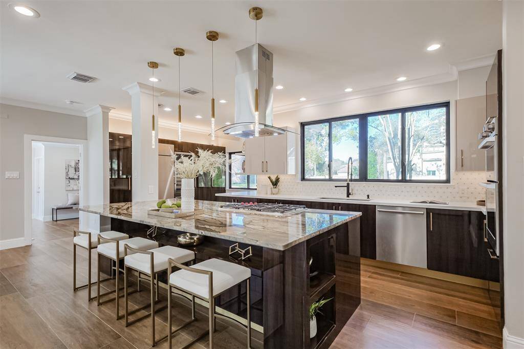 The chef’s kitchen steals the show with top of the line stainless steel appliances, expansive custom cabinetry, and a stunning quartzite island. (previously staged)