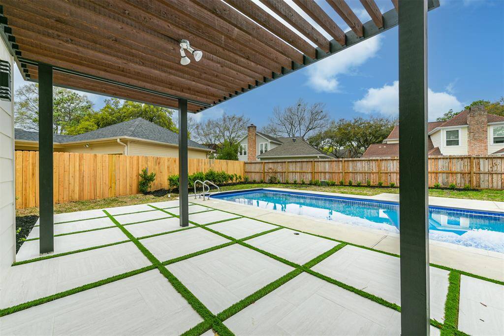 The new tile and turf patio and new pergola extend your living space outside and create the perfect place for meals after a day in the sparkling pool.