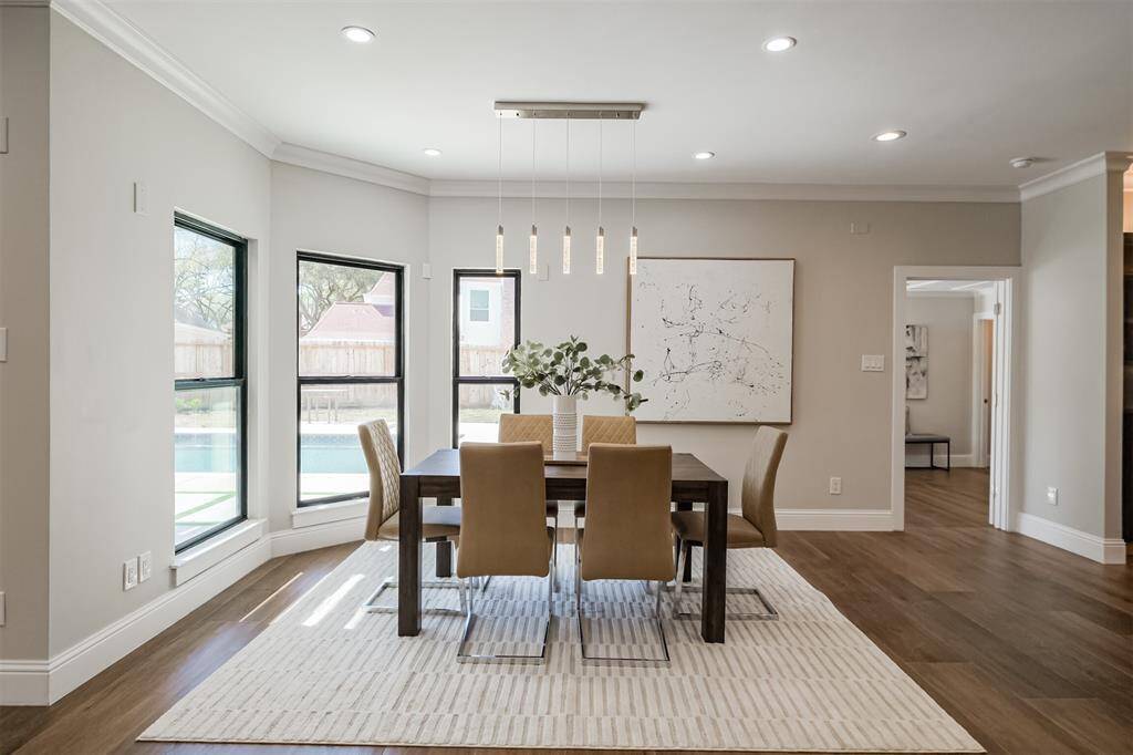 The spacious breakfast room features oversized picture windows that frame the serene beauty of the backyard providing not only a picturesque backdrop for your morning routine but also flood the space with an abundance of natural light. (previously staged)