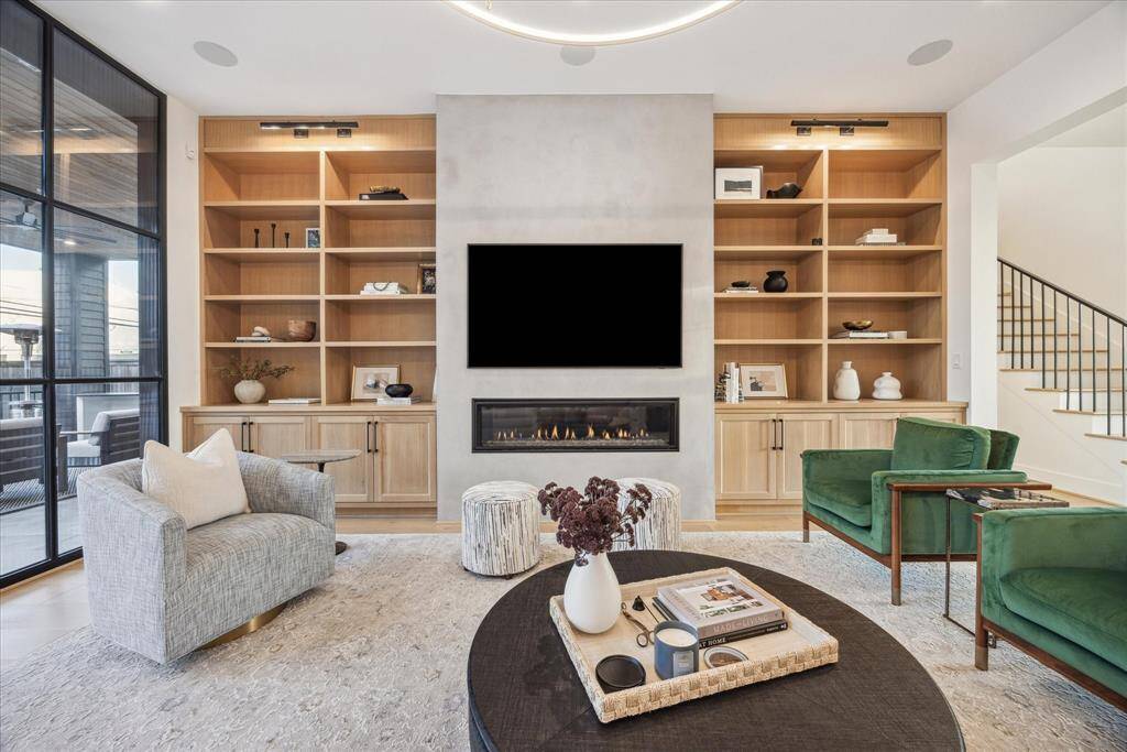 The family room captivates with its stunning contemporary design, centered around a sleek modern fireplace that adds warmth and a striking focal point.