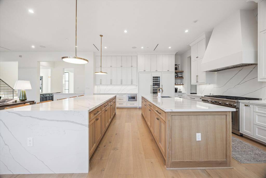 [KITCHEN] This impeccably designed kitchen is a chef’s dream, featuring two expansive center islands perfect for cooking, entertaining, and casual dining. Equipped with top-of-the-line Thermador appliances, dual dishwashers, and a built-in wine fridge, every detail has been thoughtfully planned for maximum efficiency and style.