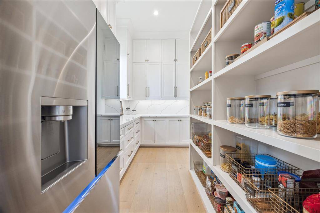 [PANTRY] The expansive walk-in pantry provides ample storage, thoughtfully designed to accommodate all your culinary essentials with ease and organization. This generous space perfectly complements the contemporary kitchen, combining practicality with seamless style