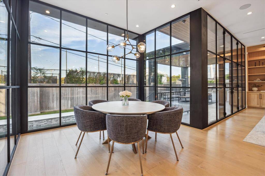 The breakfast room exudes understated elegance with a striking light fixture that adds a touch of modern artistry. Open to the kitchen and adjoining living spaces, it offers a seamless flow ideal for both everyday dining and relaxed entertaining
