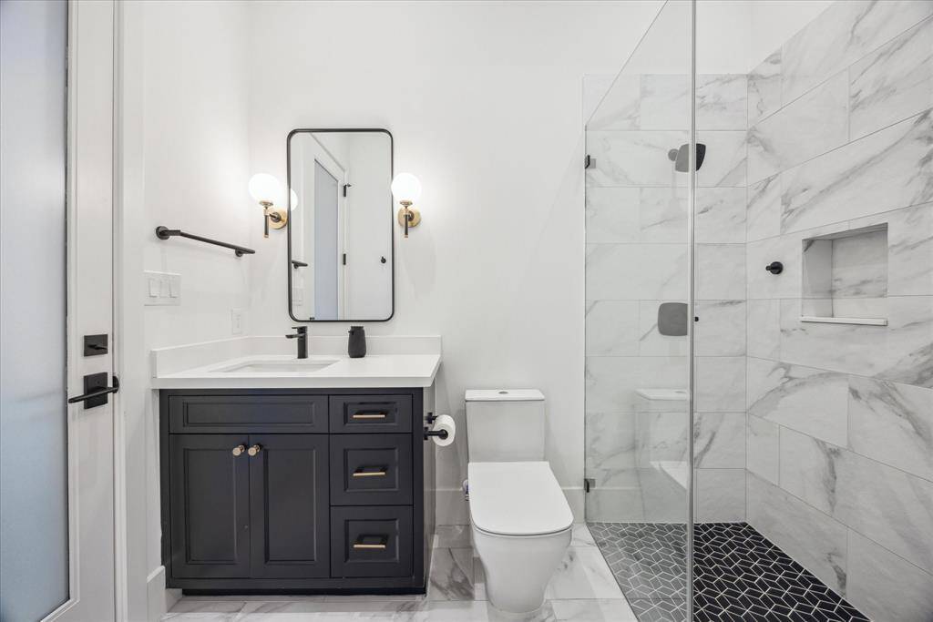 [1ST FLR GUEST BATHROOM] The guest en-suite bathroom is both stylish and functional, featuring direct outdoor access to conveniently serve as a pool bath. Designed with clean contemporary lines and quality finishes, it seamlessly blends comfort and practicality