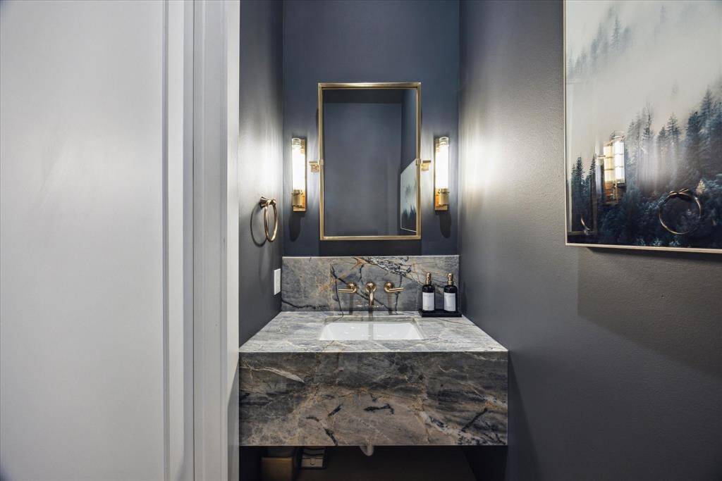 [POWDER ROOM] The powder room is a true jewel box, showcasing exquisite stone surfaces and carefully selected designer fixtures. Sophisticated and artfully styled, this space reflects the home’s contemporary elegance while offering a memorable experience for guests.