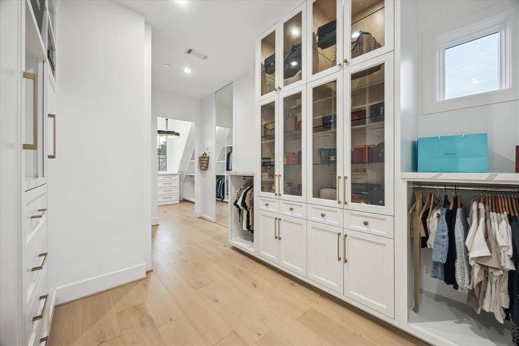 [PRIMARY CLOSET] Experience the ultimate in organization and elegance with this most expansive and absolutely stunning primary closet. Thoughtfully designed with separate his and her dedicated spaces, it offers ample room for clothing, accessories, and more.