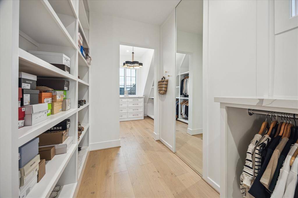 Featuring custom shoe racks and glass-enclosed shelves, this closet beautifully showcases your most treasured collections, combining contemporary sophistication with unparalleled functionality.