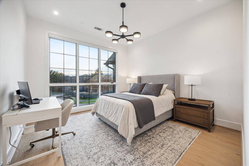 [SECONDARY BEDROOM] Spacious secondary bedroom is bathed in natural light, creating an airy and inviting atmosphere.