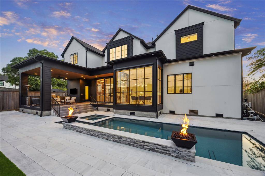 [OUTDOOR OASIS] Step into resort-style living with a breathtaking rear elevation that sets the tone for luxury and relaxation. A sparkling pool takes center stage, flanked by dramatic fire bowls that create a stunning ambiance both day and night. French glass doors and expansive windows envelop the back of the home, seamlessly blending indoor and outdoor living while flooding the interiors with natural light.