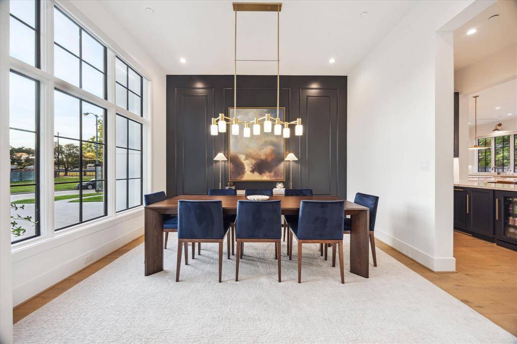 [DINING ROOM] An artful balance of sophistication and comfort, the dining room features a captivating designer light fixture that serves as a true focal point. Framed by expansive windows, the space is bathed in daylight, creating a warm and inviting setting for memorable meals and gatherings.