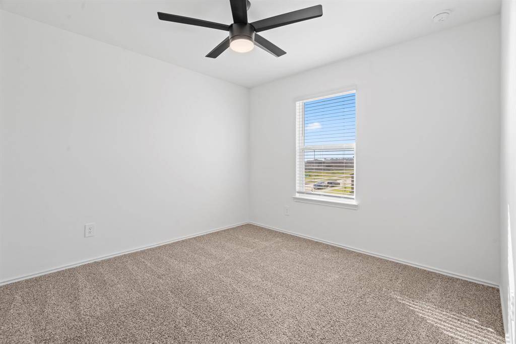 Bright and tranquil secondary bedroom with plush carpet and natural light