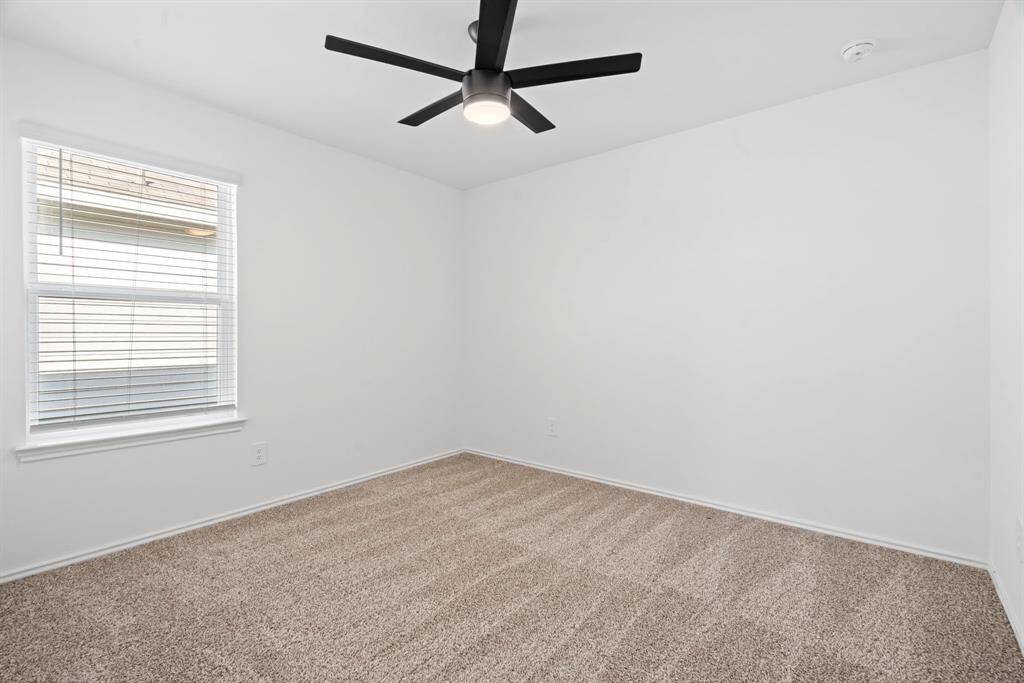 A third-secondary bedroom offers soft carpeting and natural light—perfect for comfort and rest.