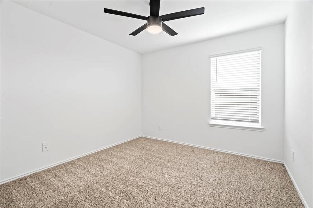 The fourth secondary bedroom continues the home’s clean, modern style with neutral tones and a bright windowed view