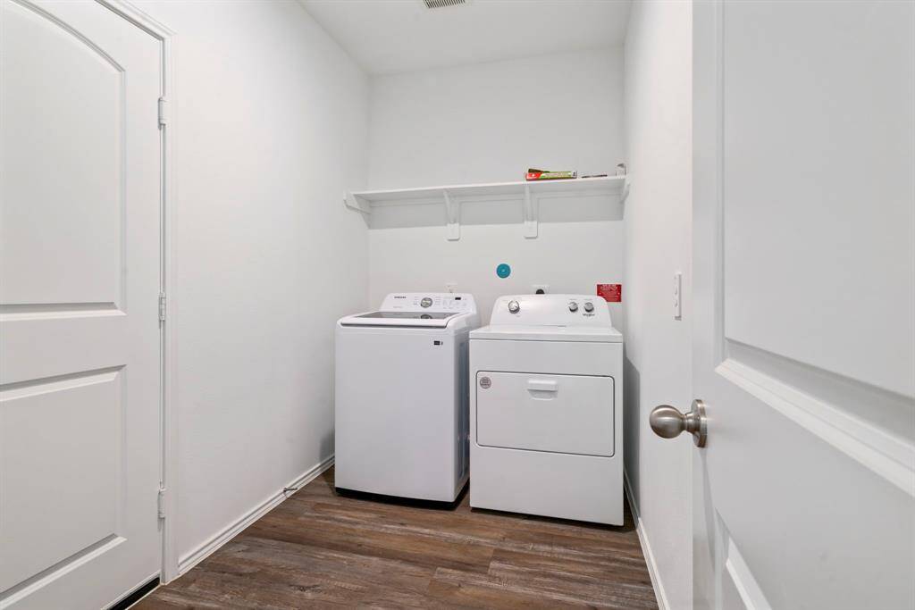 Dedicated laundry room equipped with washer, dryer, and an overhead shelf for convenience