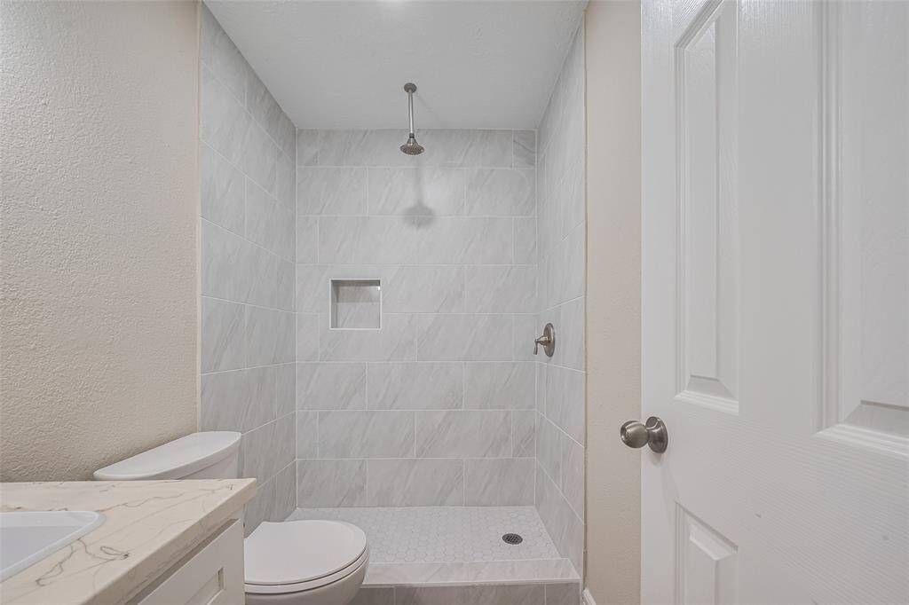 With finishes similar to the primary suite, this bathroom offers a quiet sense of balance with a vanity, updated fixtures, and a clean-lined shower surround.