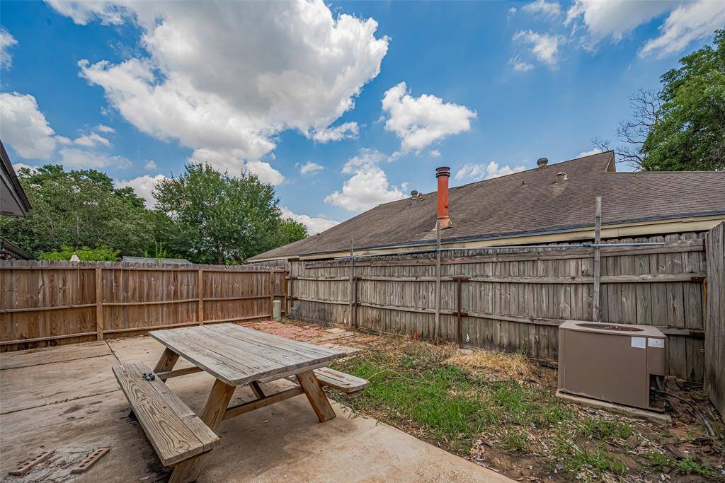 Mostly paved for low-maintenance ease, the backyard still leaves room for a touch of green.