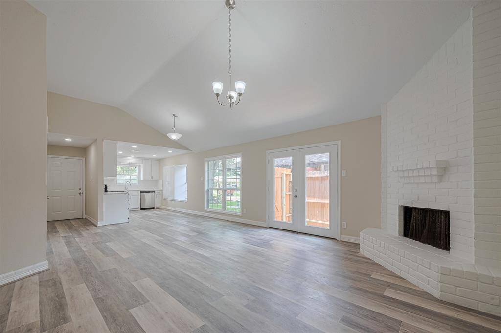 The seamless flow of wood-toned vinyl underfoot connects this room to the adjacent kitchen and dining areas, creating an atmosphere of openness and cohesion.