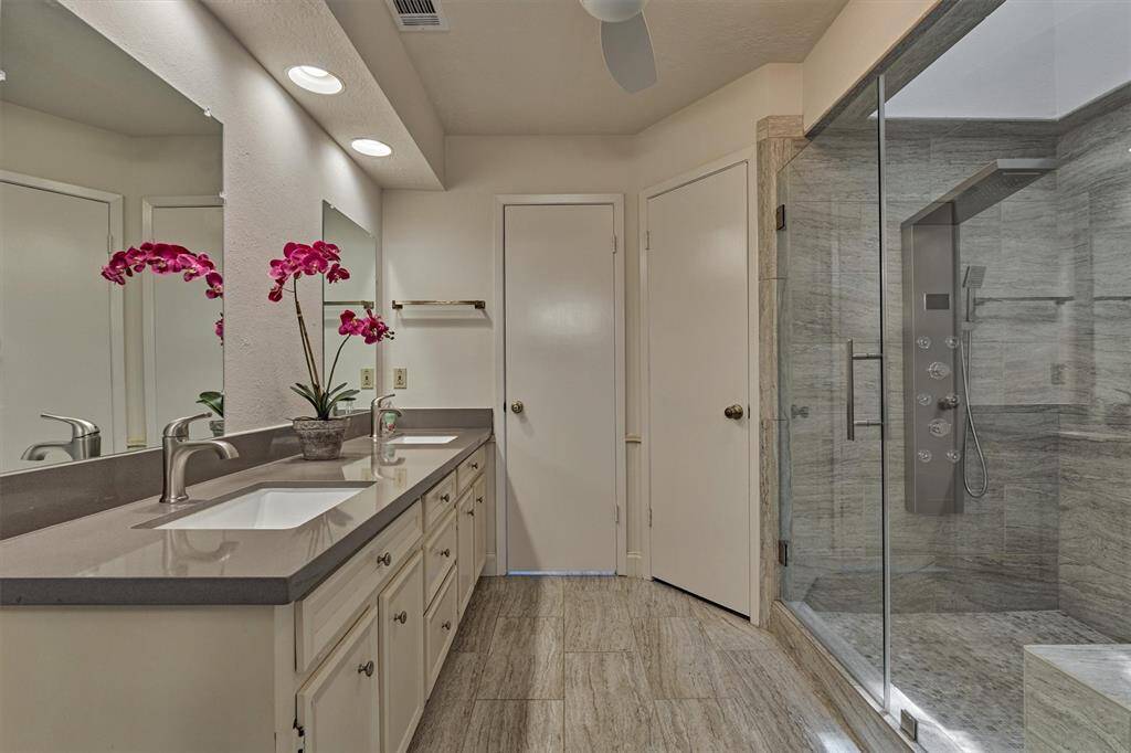 Luxe primary retreat bathroom is beautifully updated with dual sinks and XL walk-in shower with new shower head!